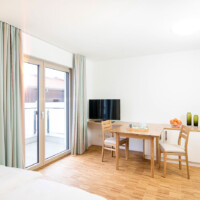 1 Zimmer-Apartment TV und Esstisch